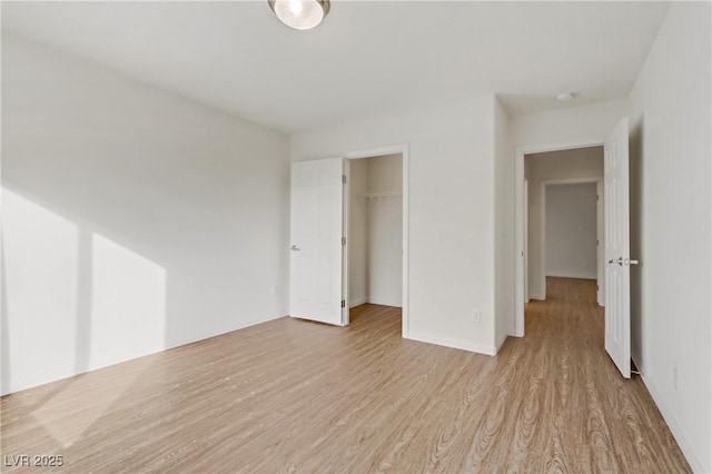 unfurnished bedroom featuring light hardwood / wood-style flooring and a closet