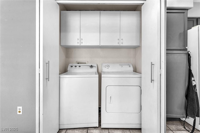 clothes washing area with cabinets and washing machine and clothes dryer