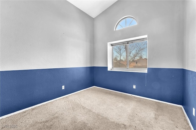 carpeted spare room featuring lofted ceiling