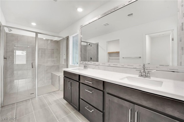 bathroom with tile patterned floors, vanity, and a shower with shower door