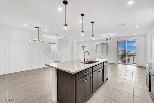 kitchen with pendant lighting, sink, dishwasher, an inviting chandelier, and an island with sink