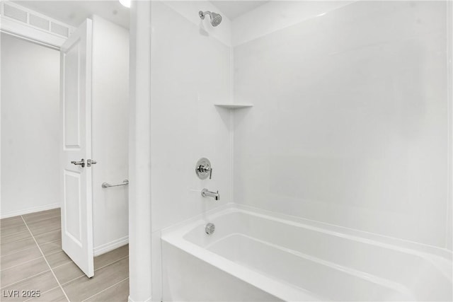 bathroom featuring tile patterned flooring and bathing tub / shower combination