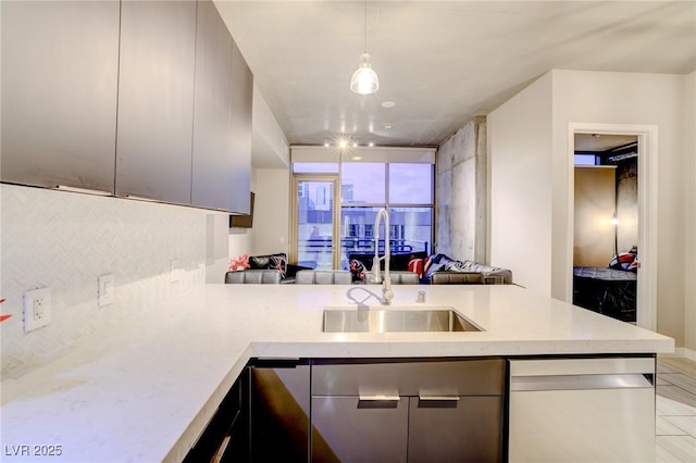 kitchen with sink, decorative light fixtures, kitchen peninsula, and dishwasher