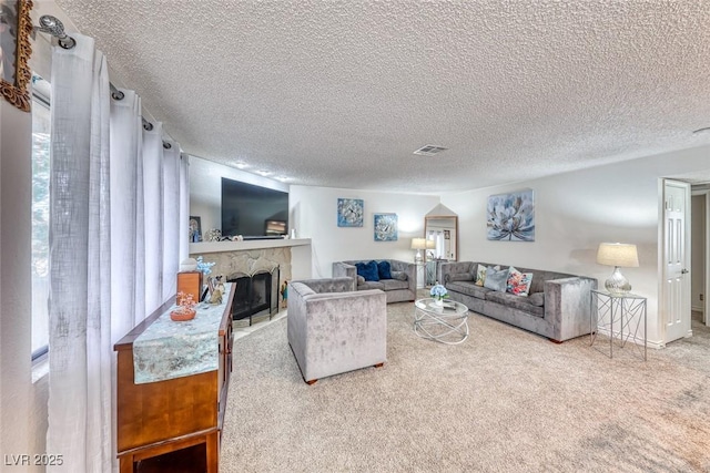 living room featuring a fireplace, carpet flooring, and a textured ceiling