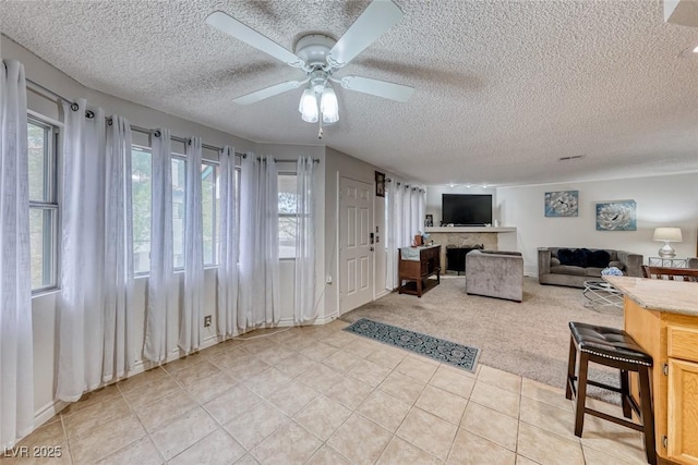 living room with light carpet, a textured ceiling, and ceiling fan