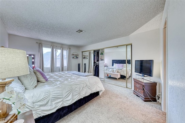 bedroom with light colored carpet, a textured ceiling, and a closet