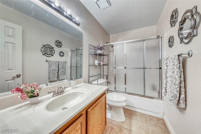 full bathroom with shower / bath combination with glass door, tile patterned flooring, vanity, a textured ceiling, and toilet