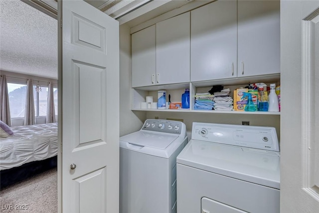 laundry room with washer and dryer, carpet floors, cabinets, and a textured ceiling