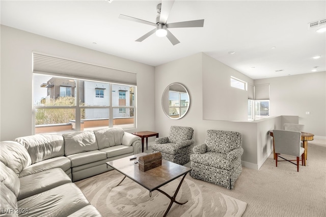 carpeted living room with ceiling fan