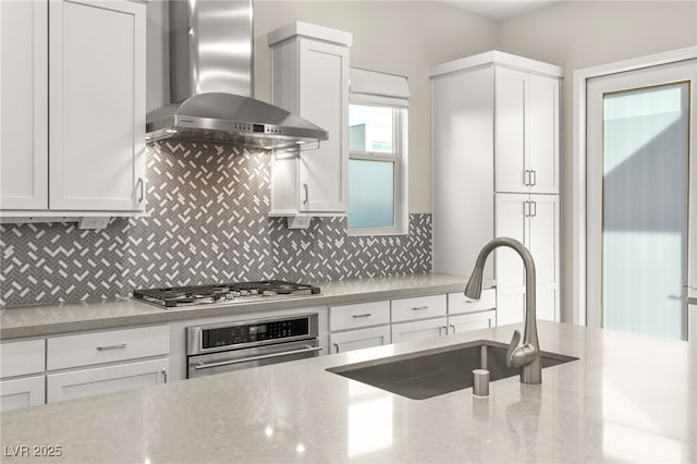 kitchen featuring tasteful backsplash, sink, stainless steel appliances, and wall chimney exhaust hood