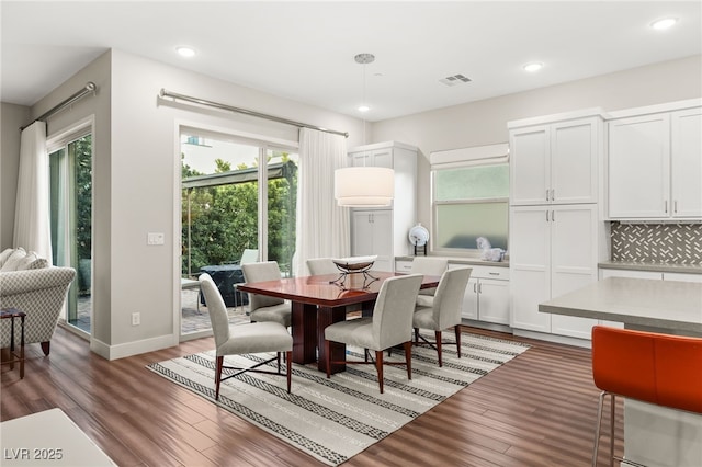 dining area featuring a healthy amount of sunlight and dark wood-type flooring