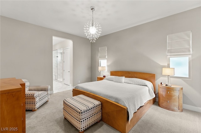 carpeted bedroom featuring an inviting chandelier and ensuite bath