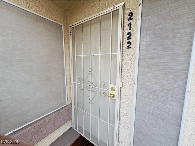 doorway to property featuring stucco siding