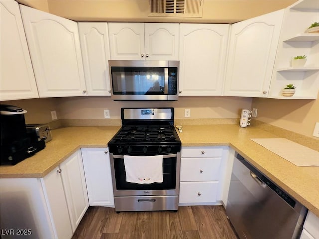 kitchen featuring visible vents, open shelves, white cabinetry, stainless steel appliances, and dark wood-style flooring