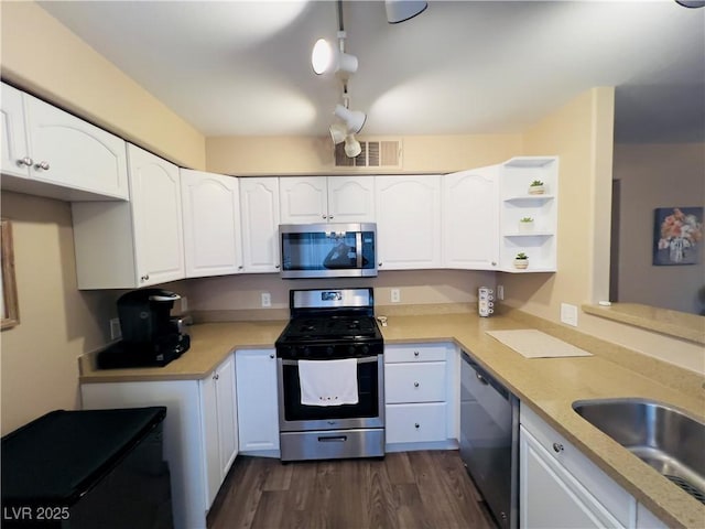 kitchen featuring white cabinets, stainless steel appliances, light countertops, and a sink