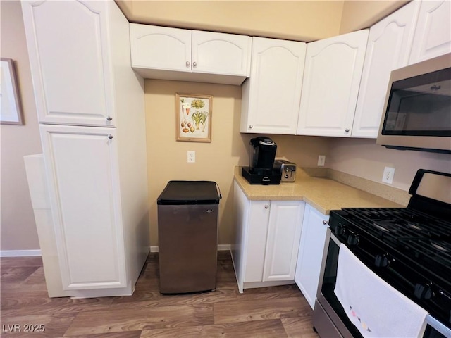 kitchen with white cabinets, appliances with stainless steel finishes, and light countertops