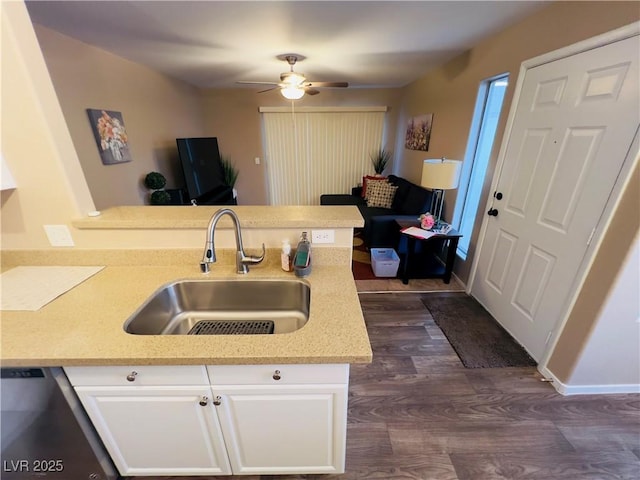 kitchen with a sink, dark wood finished floors, a peninsula, white cabinets, and dishwasher