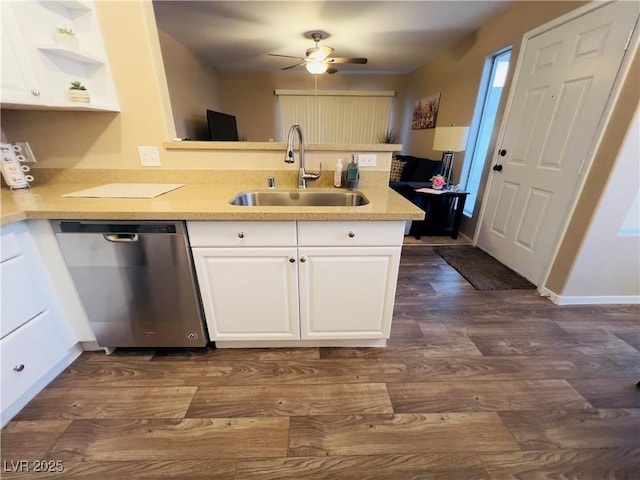 kitchen featuring dishwasher, a peninsula, white cabinetry, and a sink