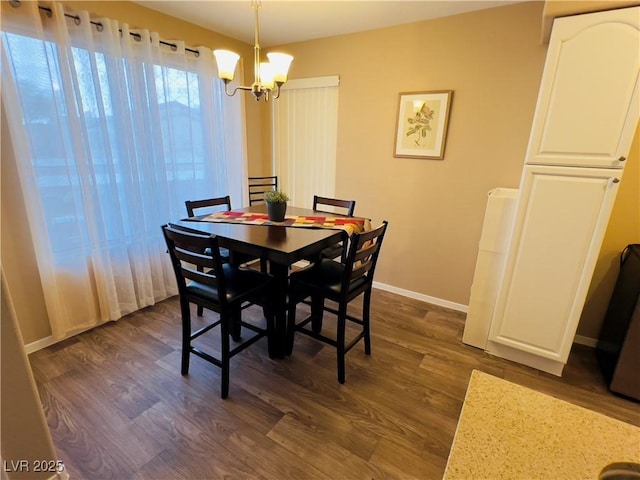 dining room featuring baseboards, dark wood-type flooring, and a notable chandelier