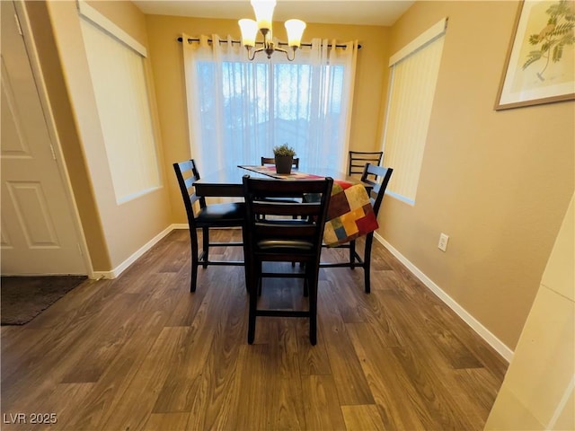 dining space featuring dark wood-style floors, an inviting chandelier, and baseboards