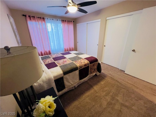 bedroom featuring two closets, ceiling fan, and carpet