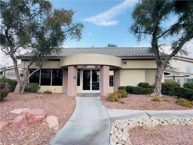 view of front of home with a tiled roof and stucco siding