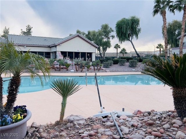 pool featuring a patio area, a sunroom, and fence