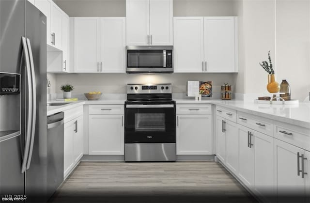 kitchen featuring stainless steel appliances, light stone countertops, sink, and white cabinets