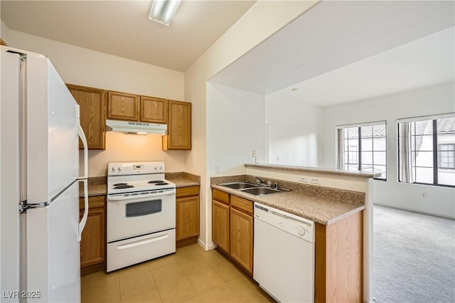 kitchen with sink, light colored carpet, white appliances, and kitchen peninsula