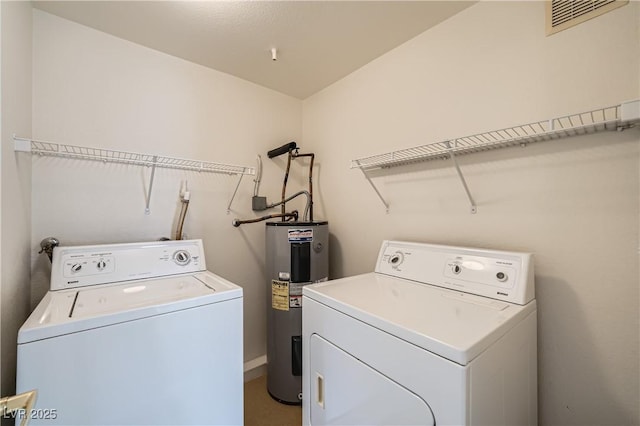 laundry area featuring water heater and washing machine and clothes dryer