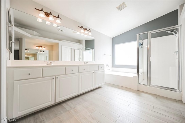 bathroom featuring hardwood / wood-style flooring, lofted ceiling, independent shower and bath, and vanity