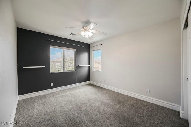 spare room with ceiling fan and carpet