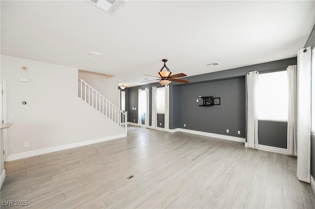 unfurnished living room featuring ceiling fan, a healthy amount of sunlight, and light wood-type flooring