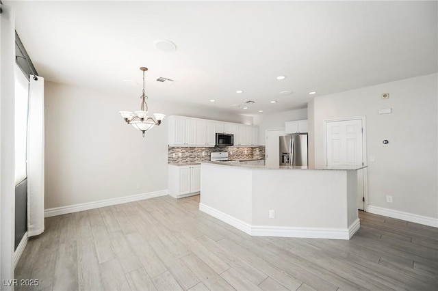 kitchen with white cabinetry, tasteful backsplash, a center island, hanging light fixtures, and stainless steel appliances