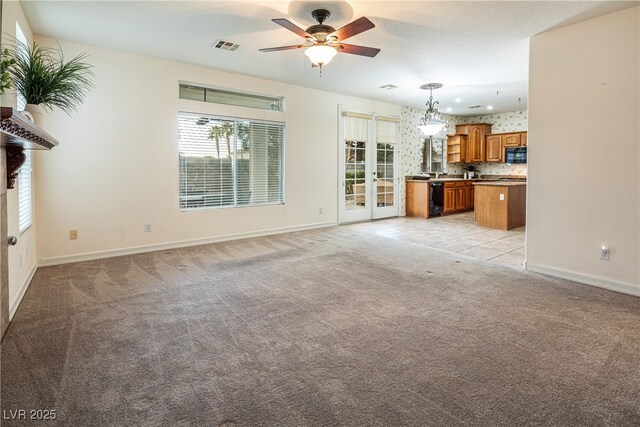 unfurnished living room featuring ceiling fan and light colored carpet