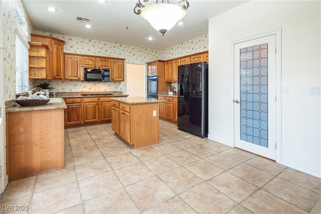 kitchen featuring light tile patterned flooring, pendant lighting, a kitchen island, and black appliances