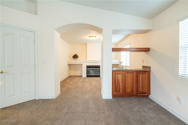 bar featuring a wealth of natural light, sink, and light carpet