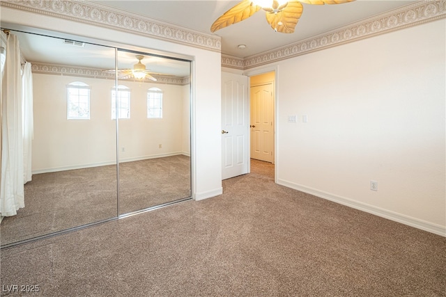 unfurnished bedroom with ceiling fan, ornamental molding, carpet flooring, and a closet