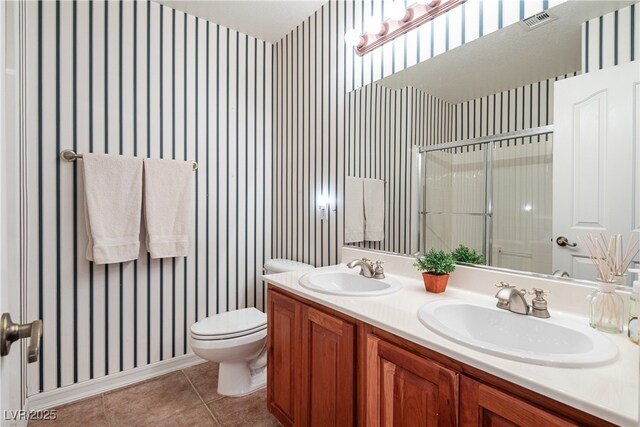 bathroom featuring tile patterned flooring, toilet, vanity, and walk in shower