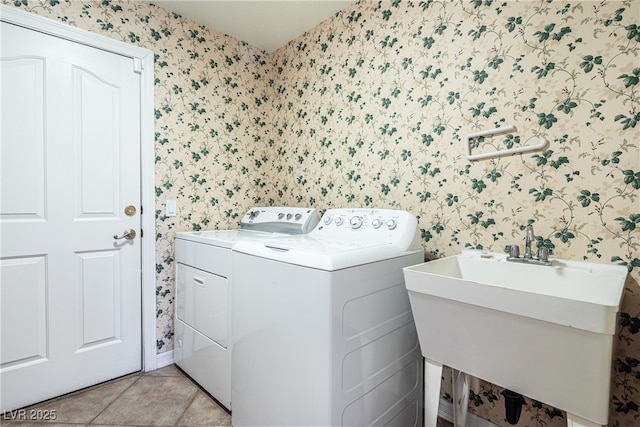 laundry room featuring sink, washer and clothes dryer, and light tile patterned flooring