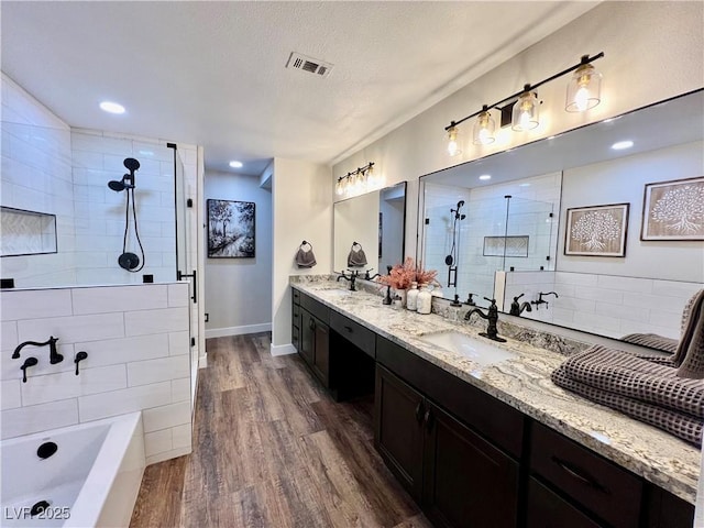 bathroom featuring wood-type flooring, separate shower and tub, a textured ceiling, and vanity