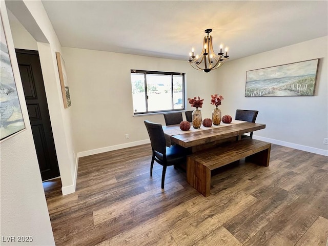 dining space with hardwood / wood-style floors and a notable chandelier