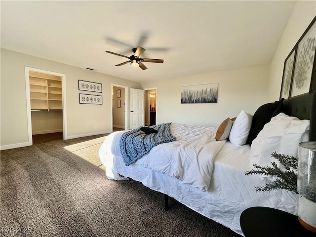 carpeted bedroom featuring ceiling fan, a spacious closet, and a closet