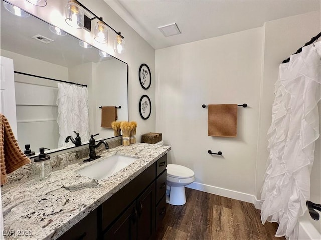 bathroom with wood-type flooring, toilet, curtained shower, and vanity