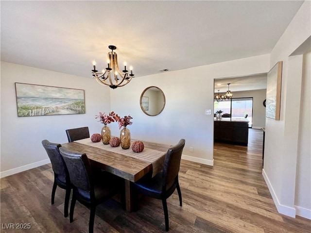 dining space featuring hardwood / wood-style floors and a chandelier