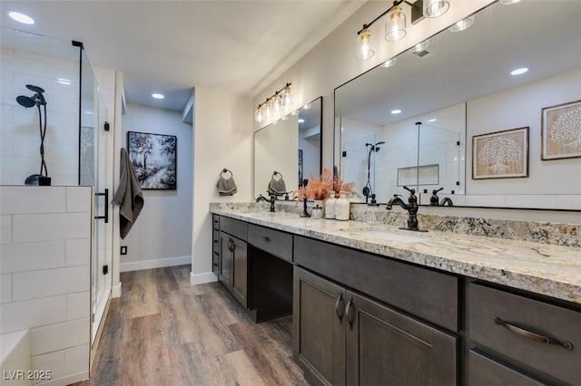 bathroom with hardwood / wood-style flooring, vanity, and a shower with shower door