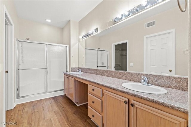 bathroom with vanity, hardwood / wood-style flooring, and a shower with shower door