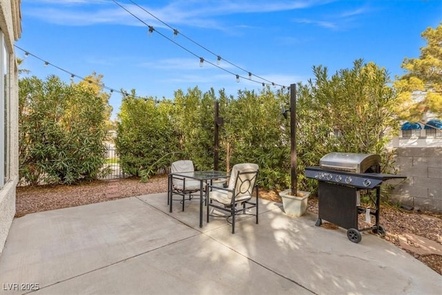 view of patio / terrace with outdoor dining space, a grill, and fence