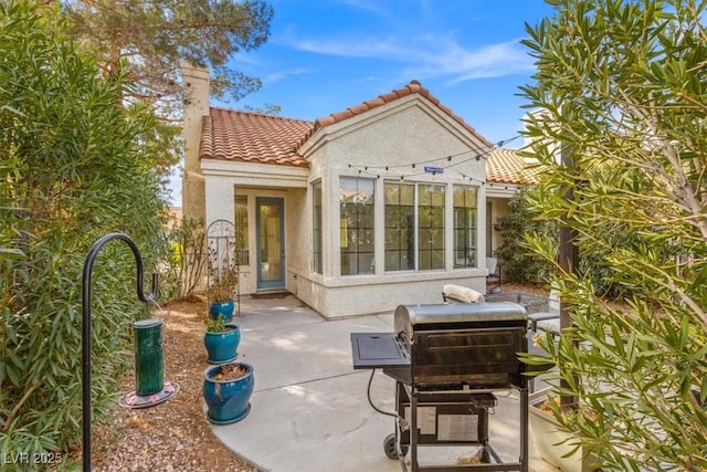 back of property featuring a tiled roof, a patio area, and stucco siding