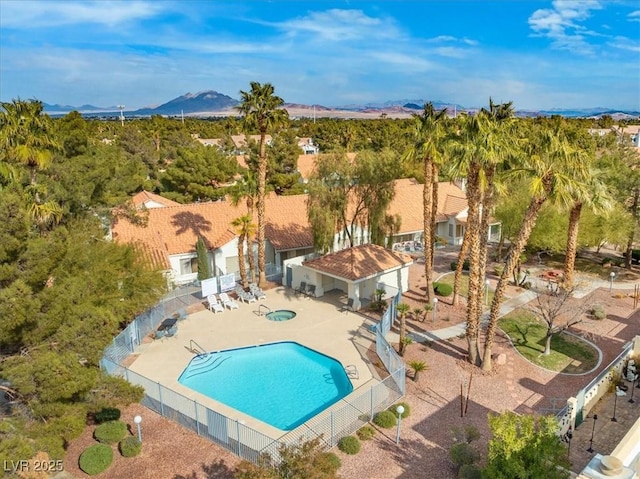 pool with a hot tub, a patio area, a mountain view, and a fenced backyard